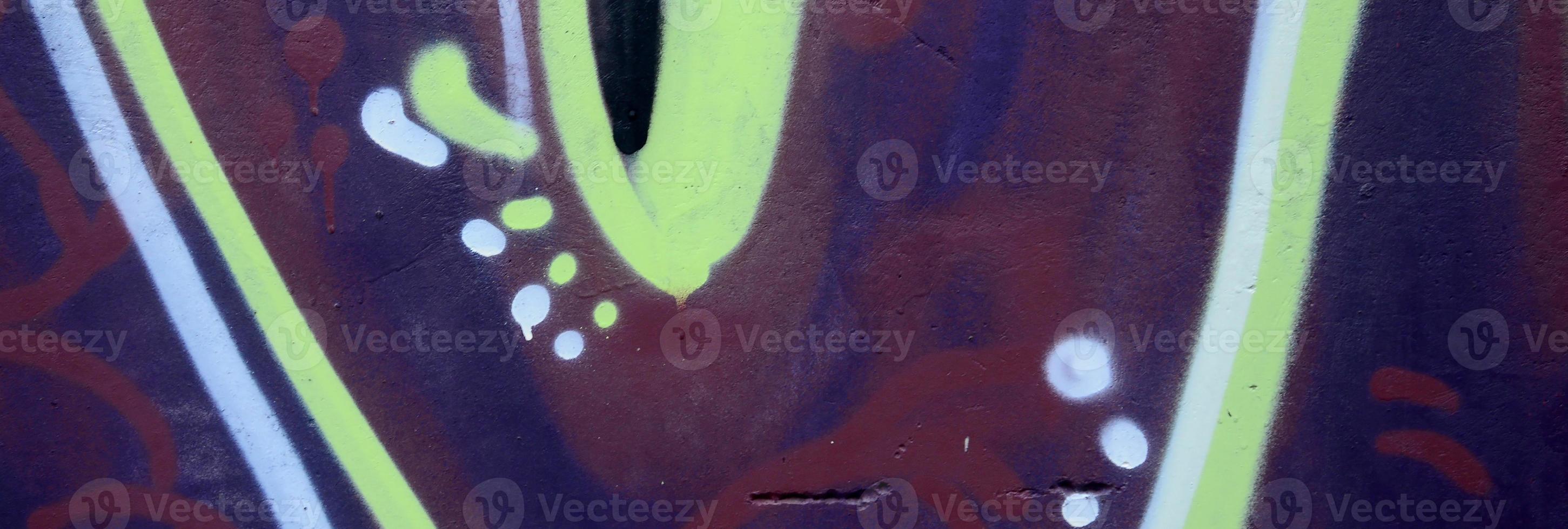 Fragment of graffiti drawings. The old wall decorated with paint stains in the style of street art culture. Colored background texture photo