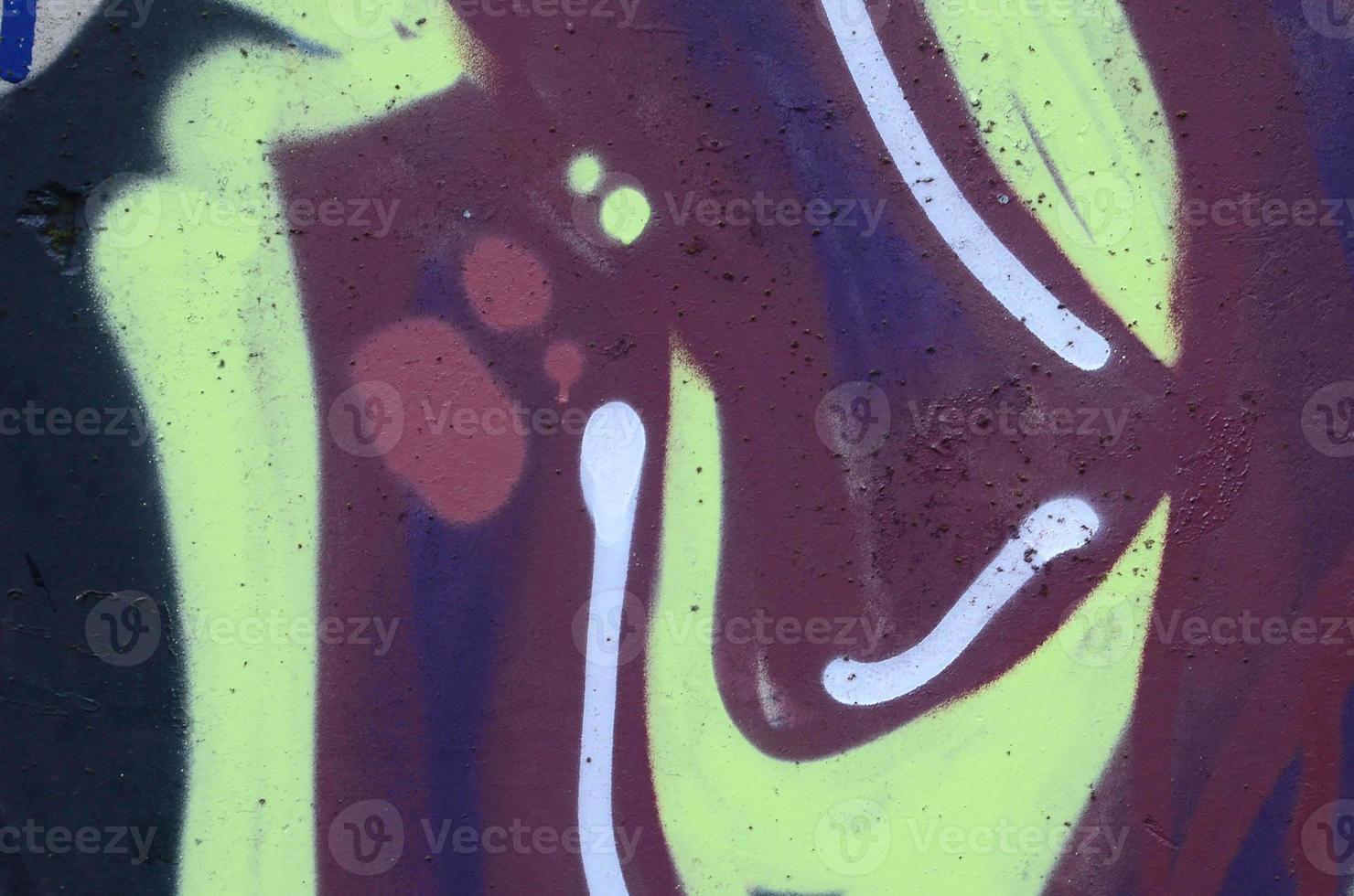 Fragment of graffiti drawings. The old wall decorated with paint stains in the style of street art culture. Colored background texture photo