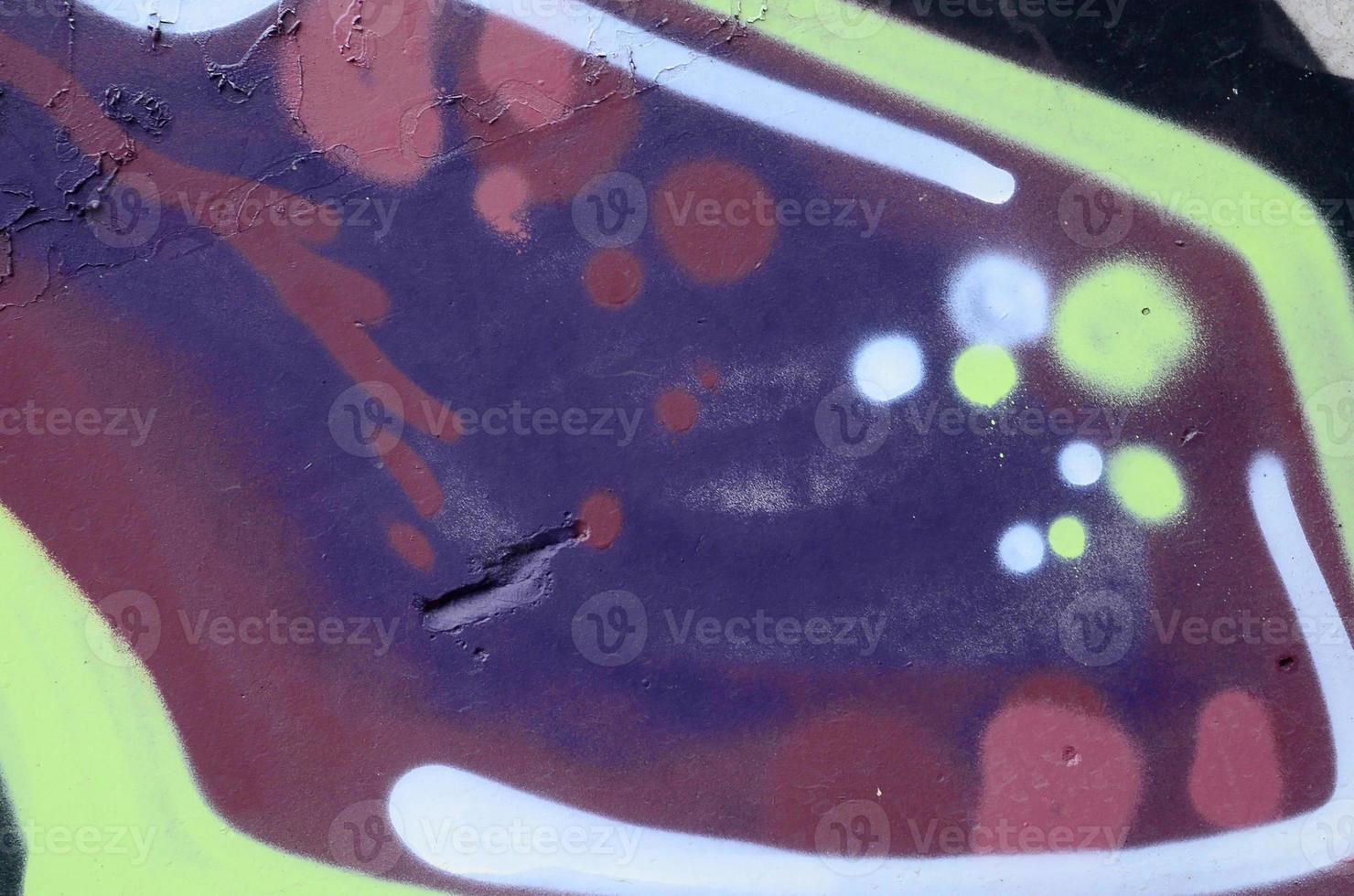 Fragment of graffiti drawings. The old wall decorated with paint stains in the style of street art culture. Colored background texture photo