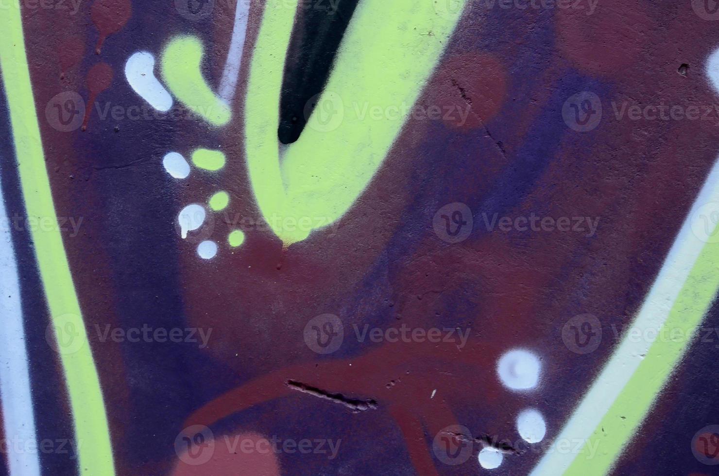 Fragment of graffiti drawings. The old wall decorated with paint stains in the style of street art culture. Colored background texture photo
