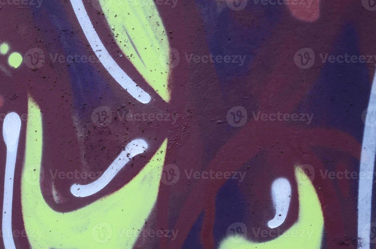 Fragment of graffiti drawings. The old wall decorated with paint stains in the style of street art culture. Colored background texture photo