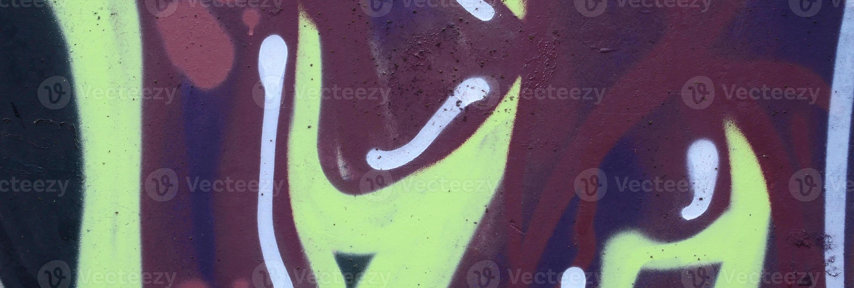 Fragment of graffiti drawings. The old wall decorated with paint stains in the style of street art culture. Colored background texture photo