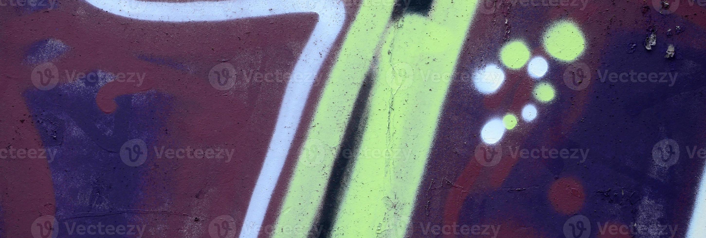 Fragment of graffiti drawings. The old wall decorated with paint stains in the style of street art culture. Colored background texture photo