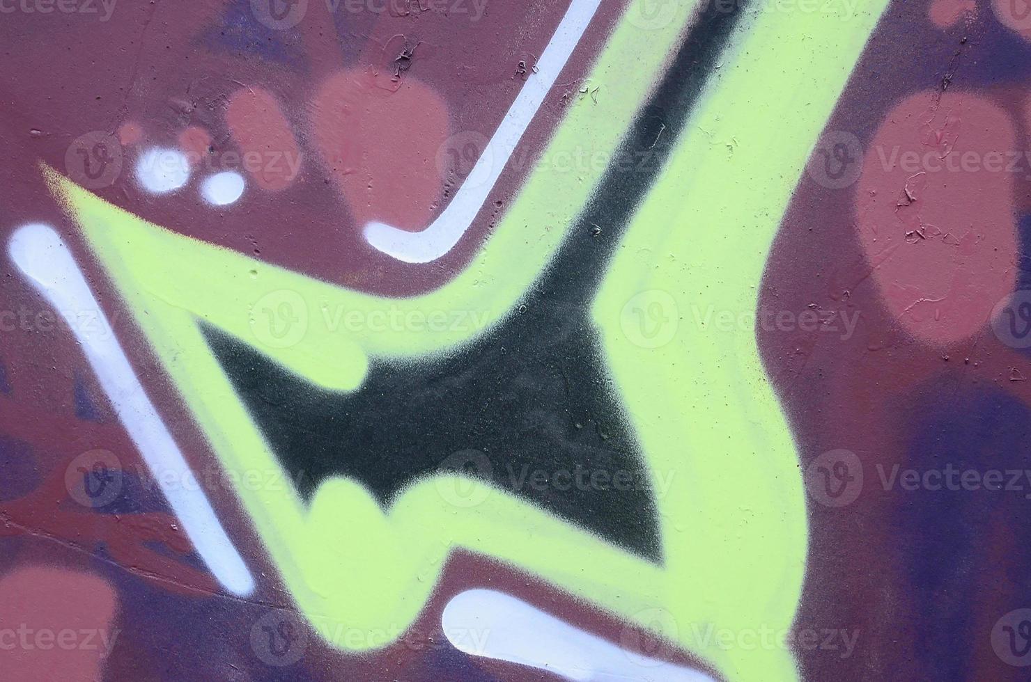 Fragment of graffiti drawings. The old wall decorated with paint stains in the style of street art culture. Colored background texture photo