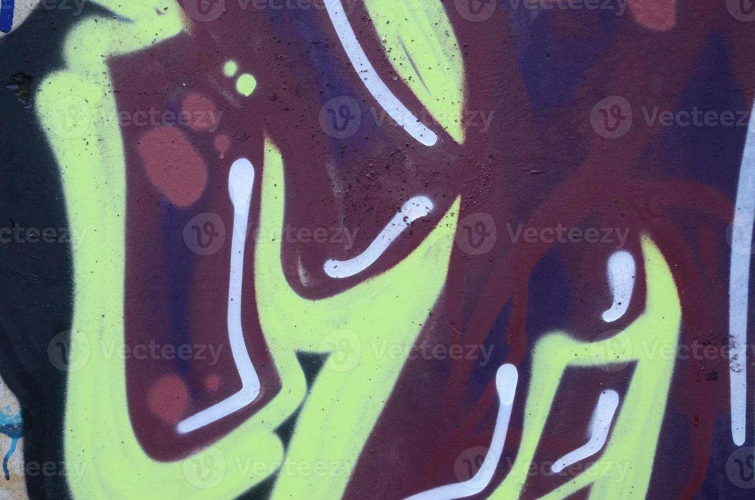Fragment of graffiti drawings. The old wall decorated with paint stains in the style of street art culture. Colored background texture photo