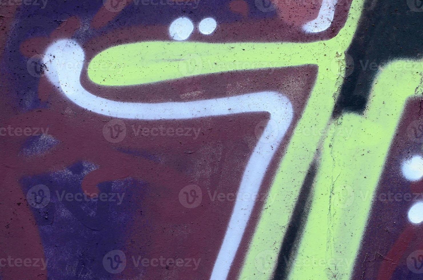 Fragment of graffiti drawings. The old wall decorated with paint stains in the style of street art culture. Colored background texture photo