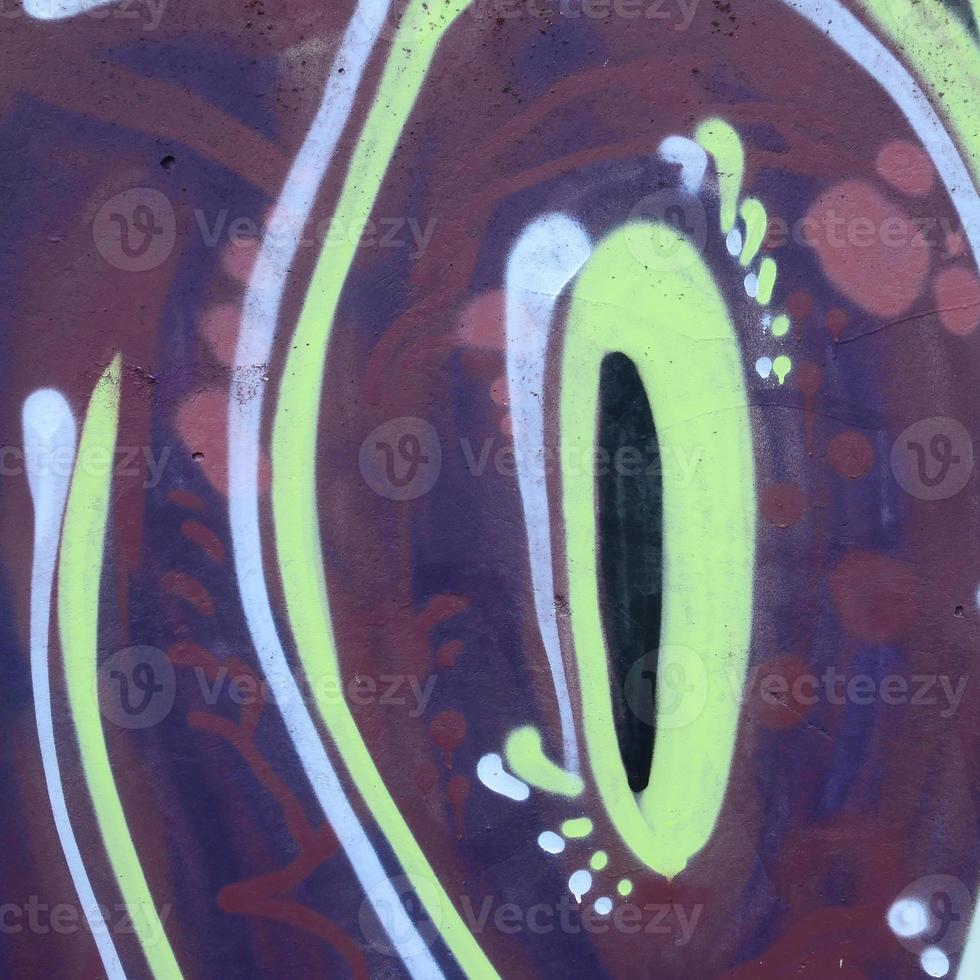 Fragment of graffiti drawings. The old wall decorated with paint stains in the style of street art culture. Colored background texture photo