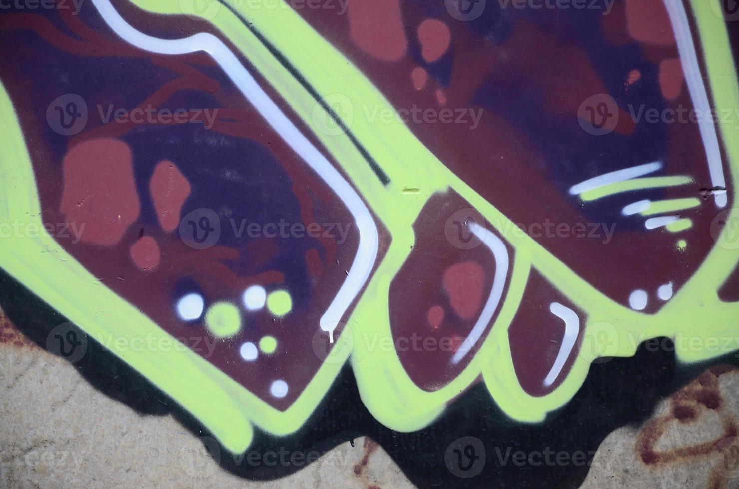 Fragment of graffiti drawings. The old wall decorated with paint stains in the style of street art culture. Colored background texture photo