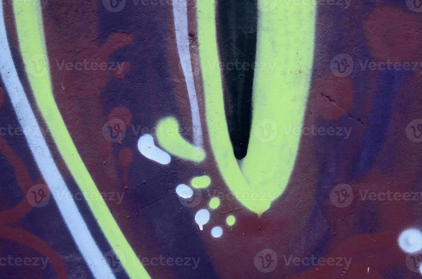 Fragment of graffiti drawings. The old wall decorated with paint stains in the style of street art culture. Colored background texture photo