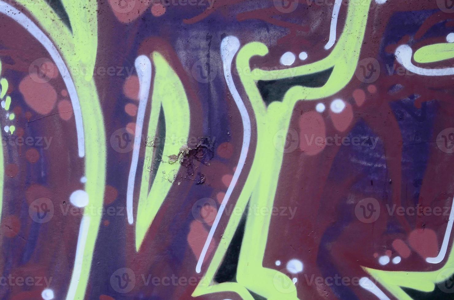 Fragment of graffiti drawings. The old wall decorated with paint stains in the style of street art culture. Colored background texture photo
