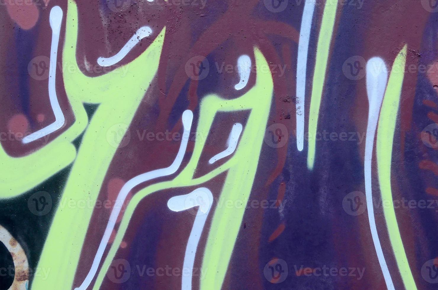 Fragment of graffiti drawings. The old wall decorated with paint stains in the style of street art culture. Colored background texture photo