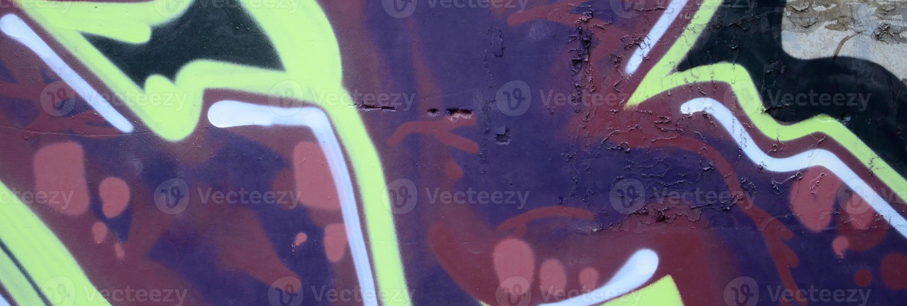 Fragment of graffiti drawings. The old wall decorated with paint stains in the style of street art culture. Colored background texture photo