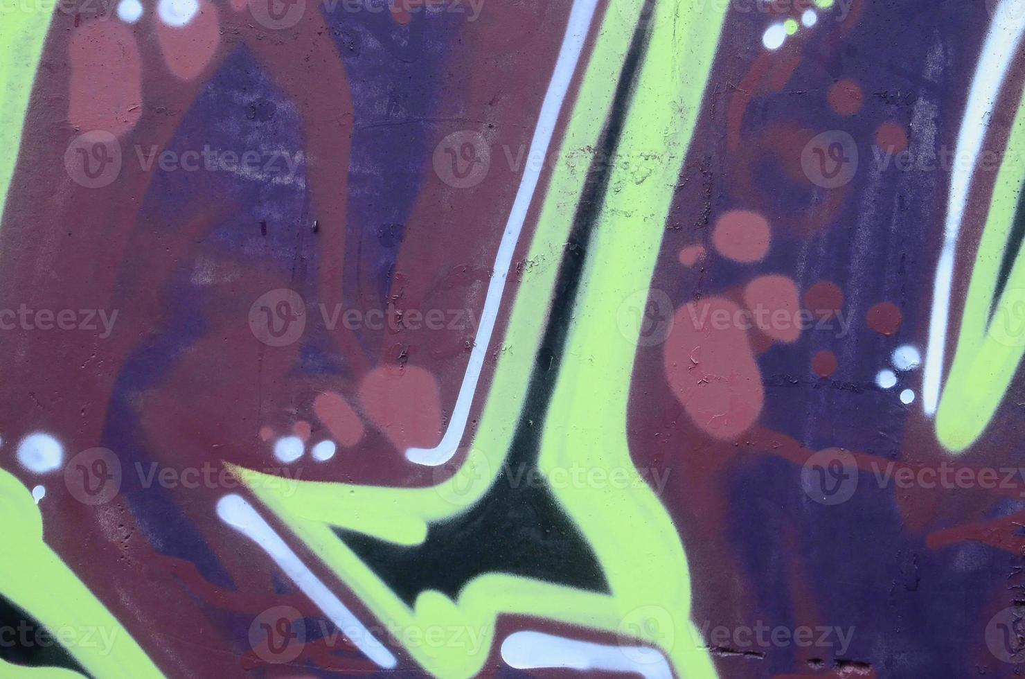 Fragment of graffiti drawings. The old wall decorated with paint stains in the style of street art culture. Colored background texture photo