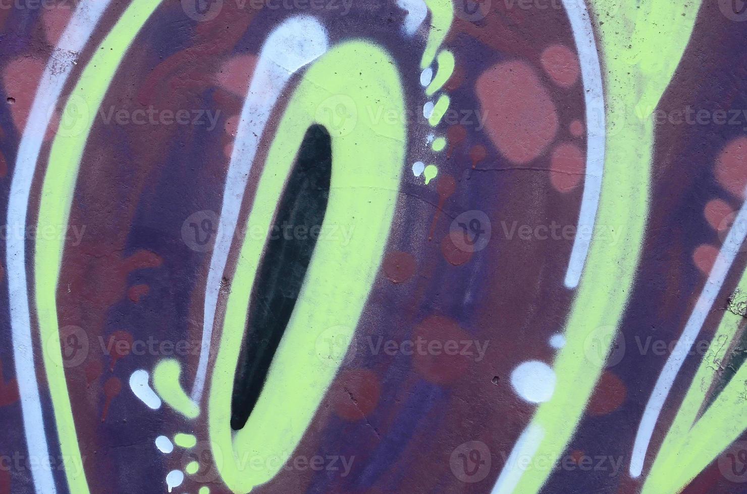 Fragment of graffiti drawings. The old wall decorated with paint stains in the style of street art culture. Colored background texture photo