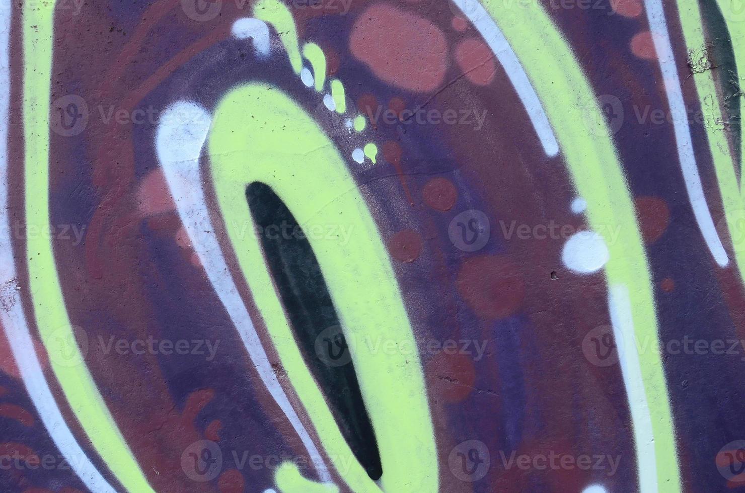 Fragment of graffiti drawings. The old wall decorated with paint stains in the style of street art culture. Colored background texture photo