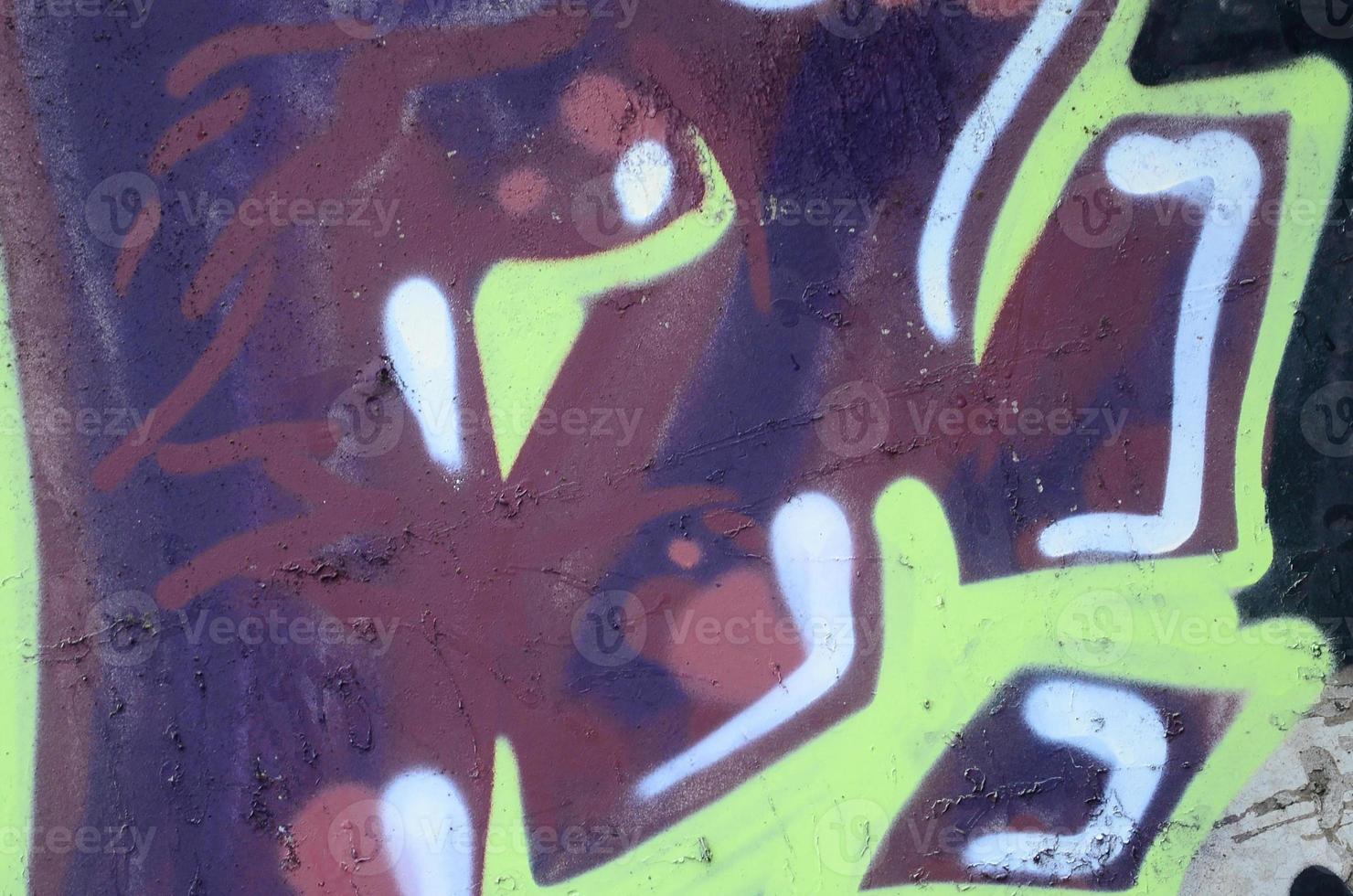 Fragment of graffiti drawings. The old wall decorated with paint stains in the style of street art culture. Colored background texture photo