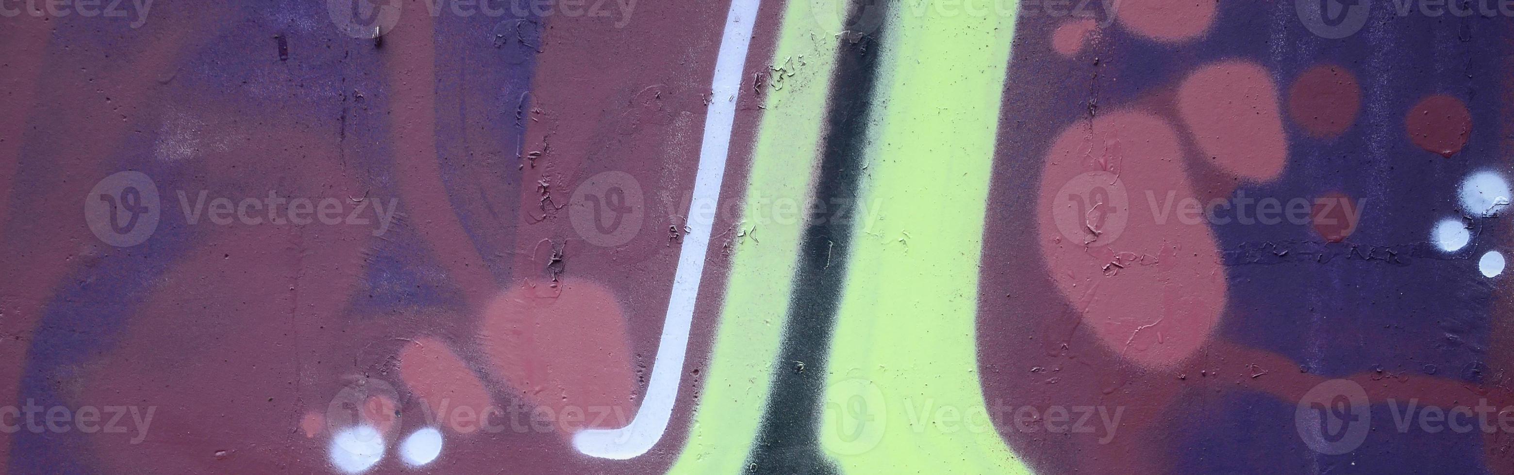 Fragment of graffiti drawings. The old wall decorated with paint stains in the style of street art culture. Colored background texture photo