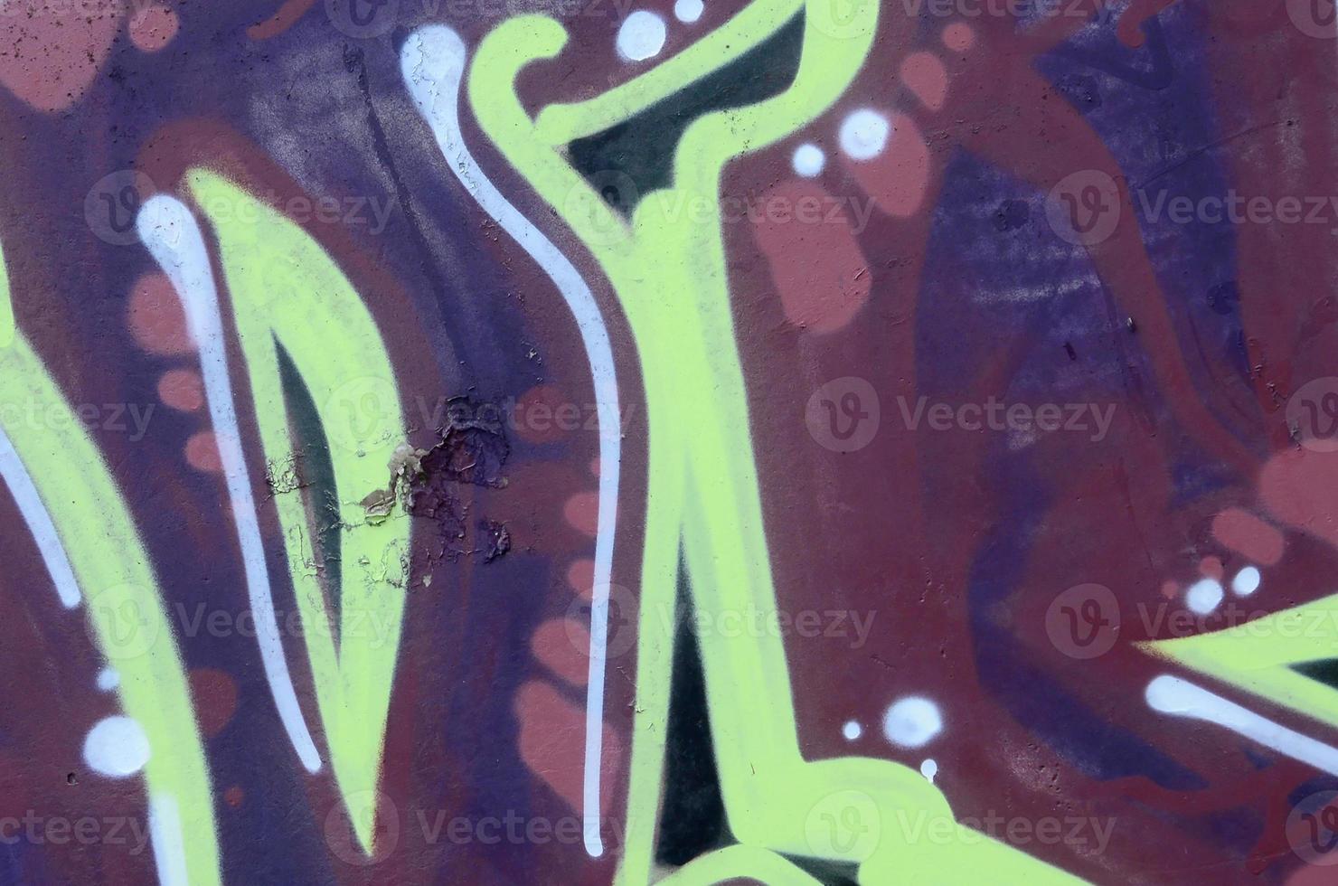 Fragment of graffiti drawings. The old wall decorated with paint stains in the style of street art culture. Colored background texture photo