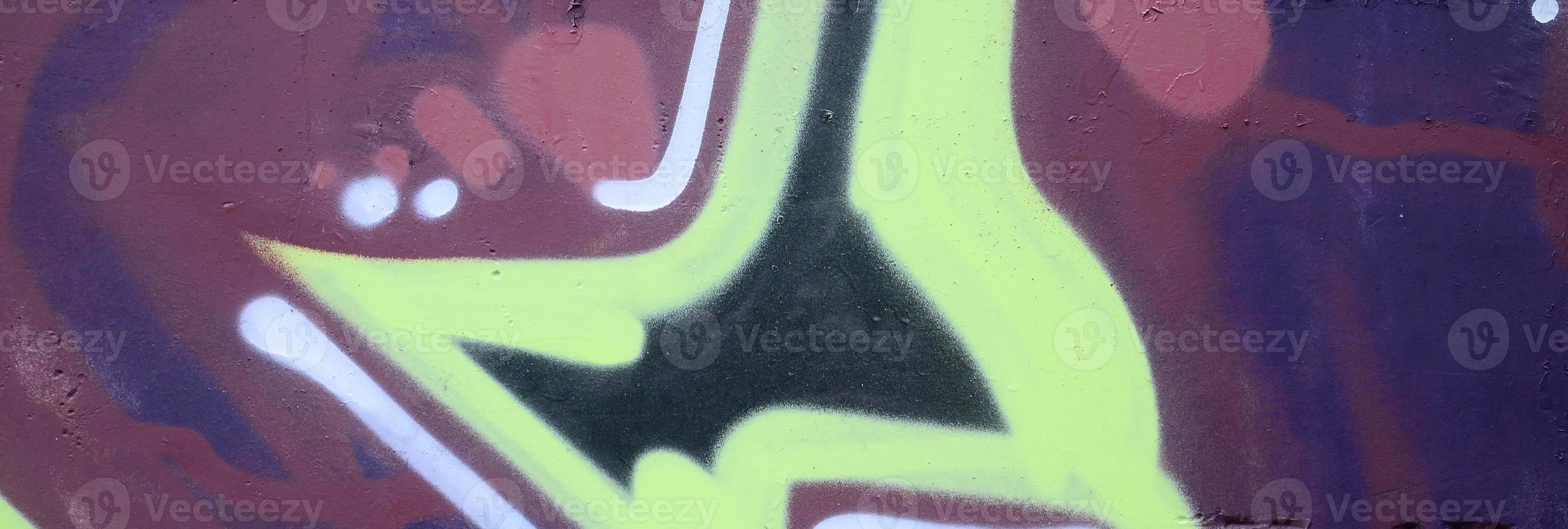 Fragment of graffiti drawings. The old wall decorated with paint stains in the style of street art culture. Colored background texture photo