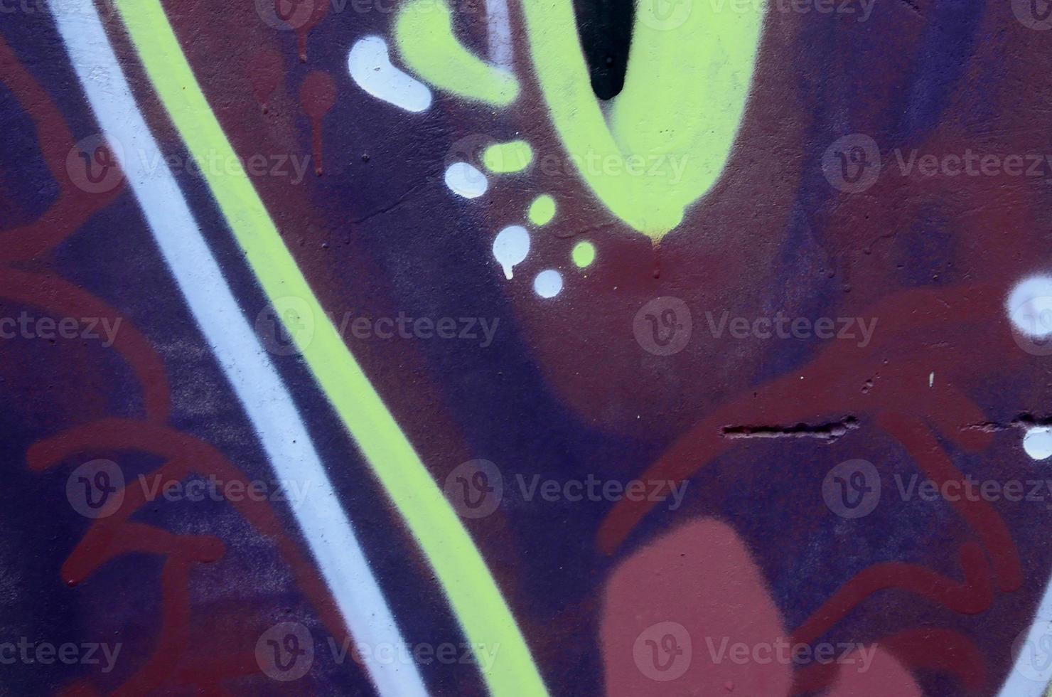 Fragment of graffiti drawings. The old wall decorated with paint stains in the style of street art culture. Colored background texture photo