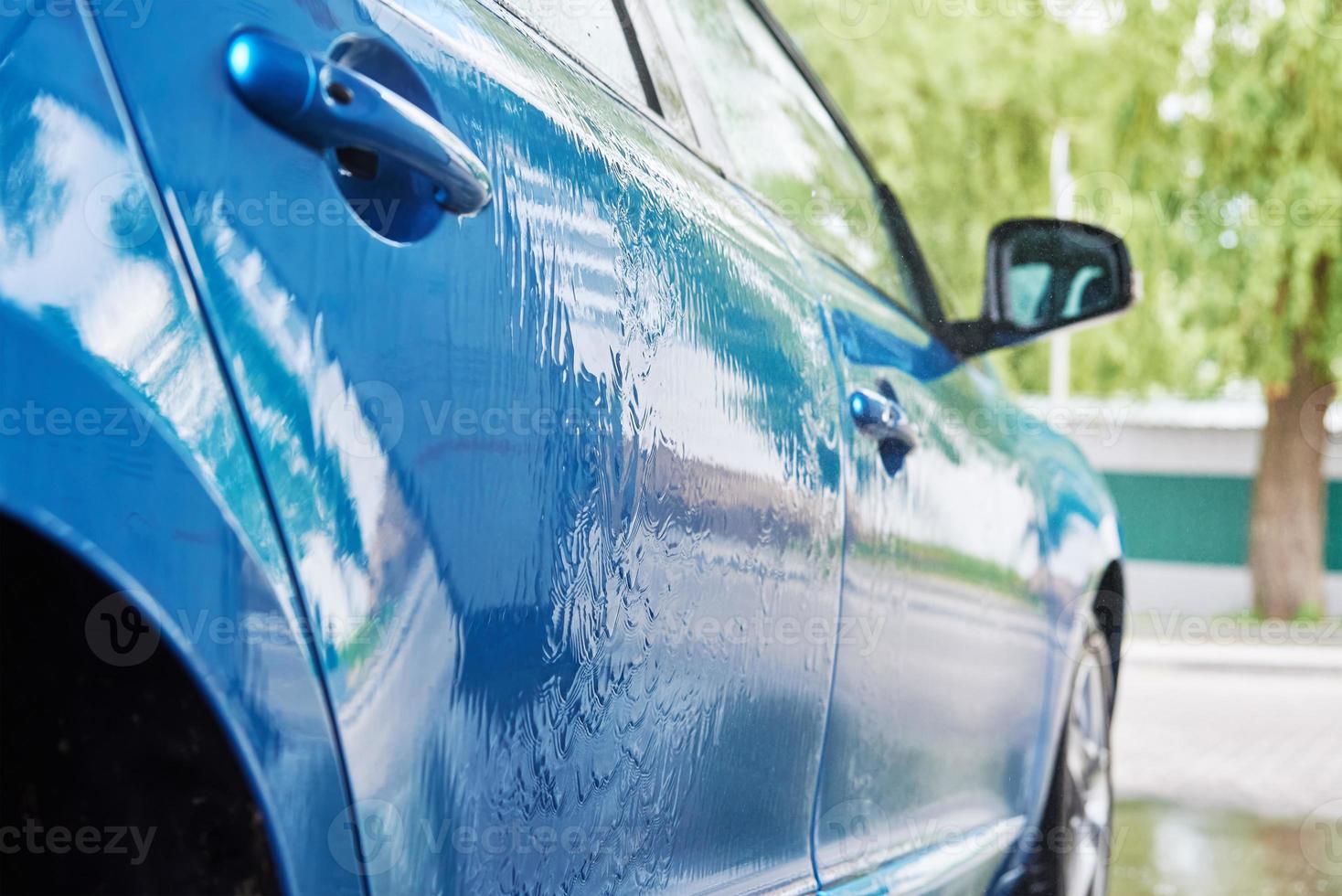 coche de limpieza con agua a alta presión en la estación de lavado de coches foto