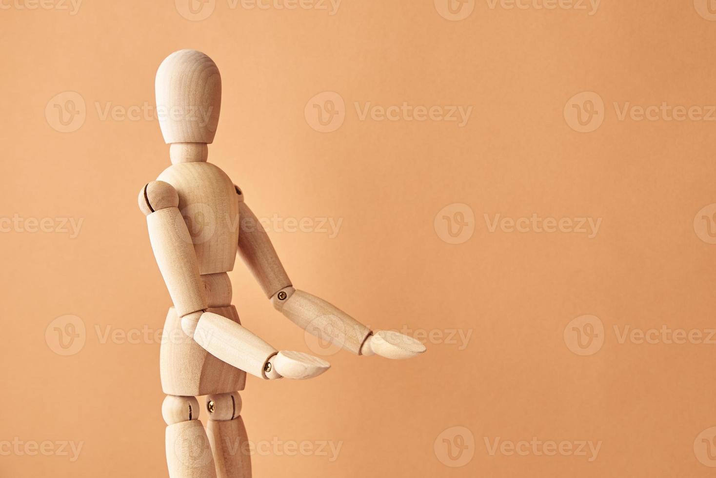 Wooden doll on beige background photo