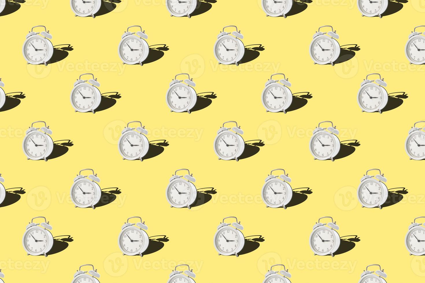 Seamless pattern with vintage alarm clock on yellow background photo