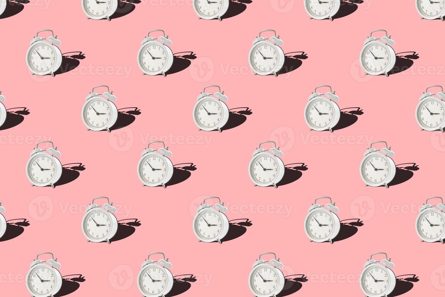 Seamless pattern with vintage alarm clock on pink background photo