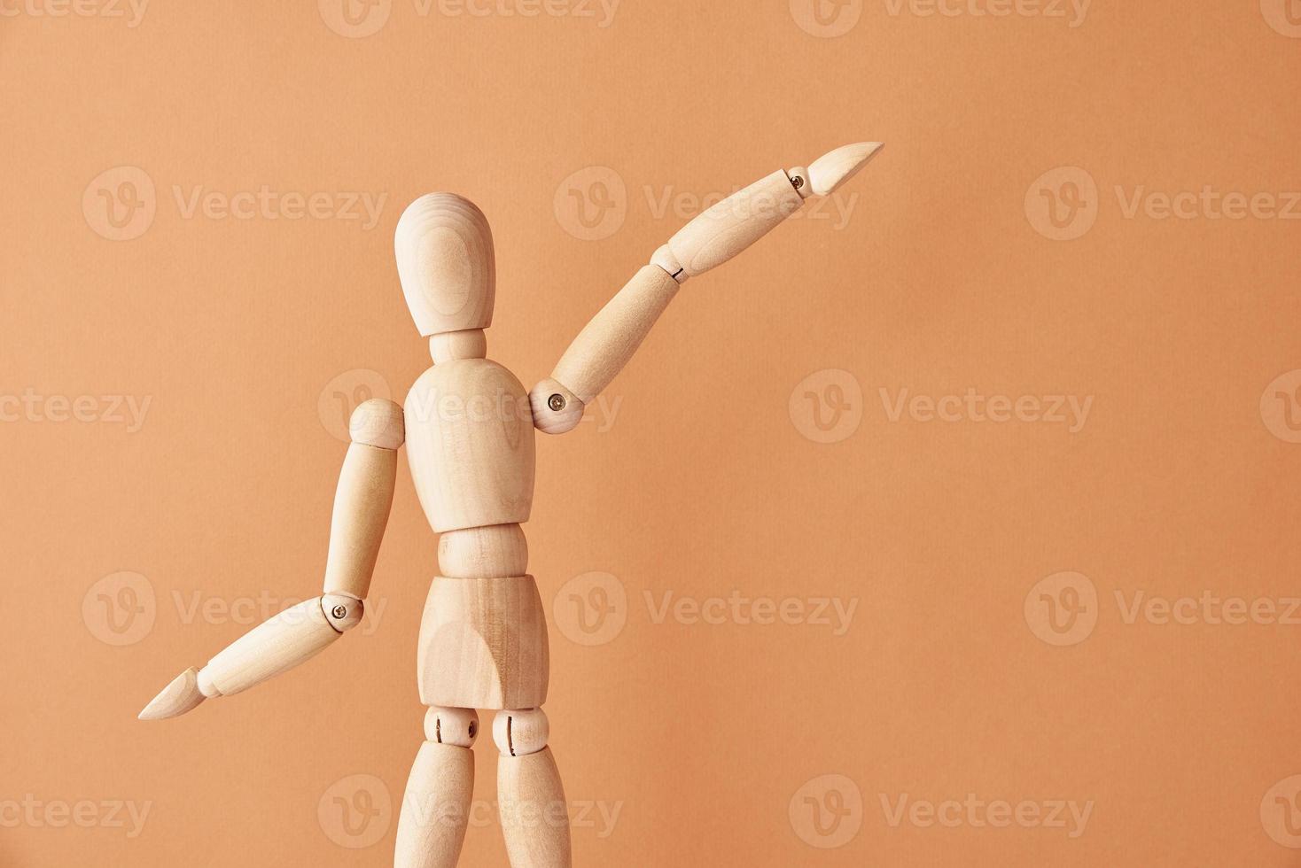 Wooden doll on beige background photo