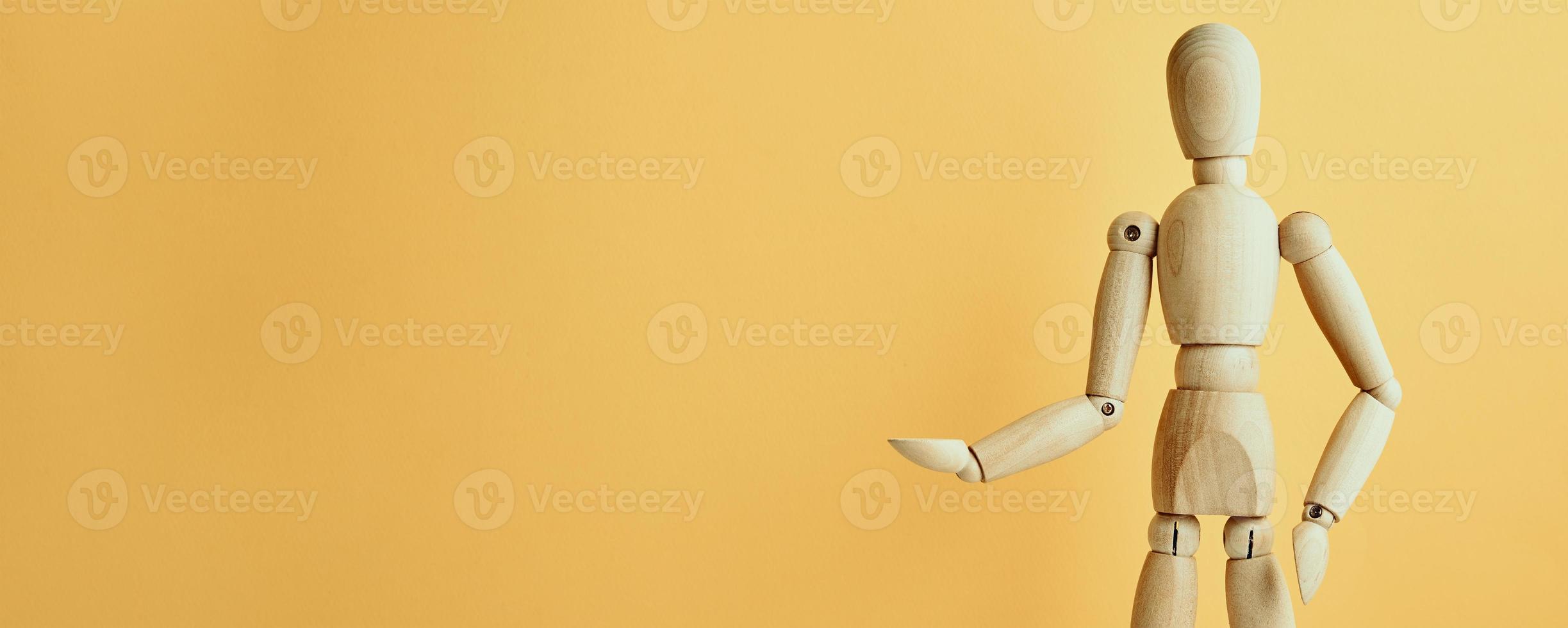 Wooden doll on yellow background photo