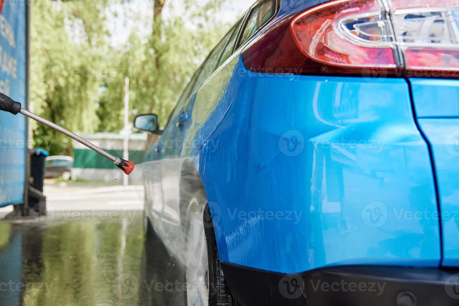 Cleaning car with high pressure water at car wash station 17007835