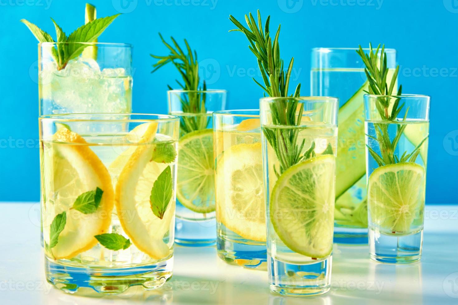 Drink with lime and rosemary on blue background photo