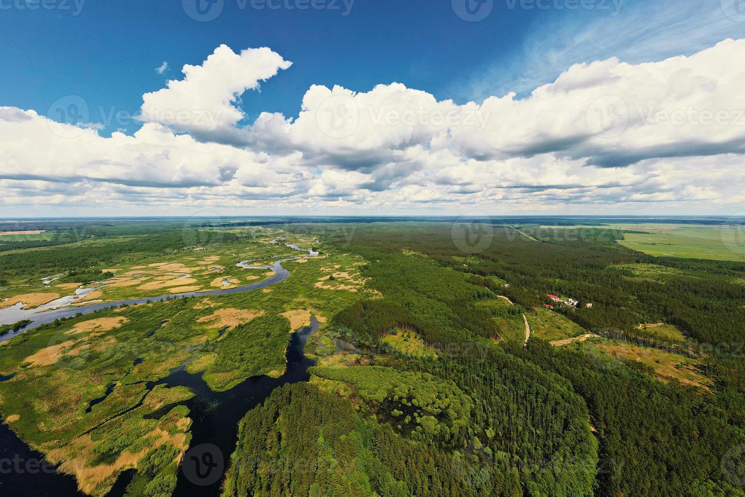 cielo azul nublado sobre el paisaje de la llanura aluvial del río y el bosque verde, vista aérea foto