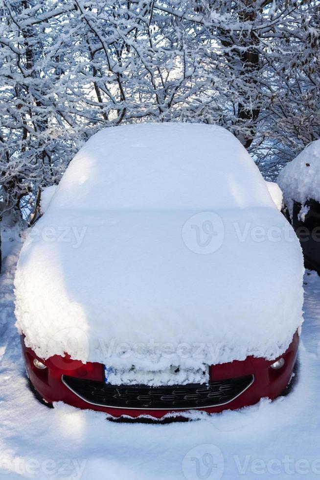 A car completely covered with thick snow after a snowstorm. photo