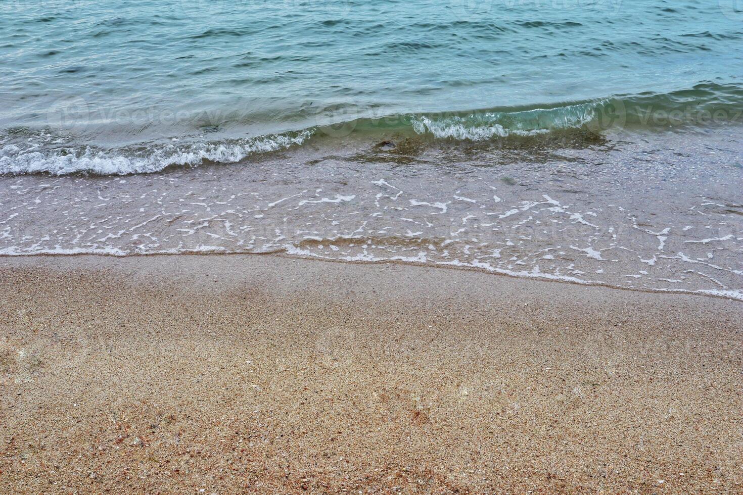 Sea coast and moving wave at the sandy beach for background and inspirational text. photo