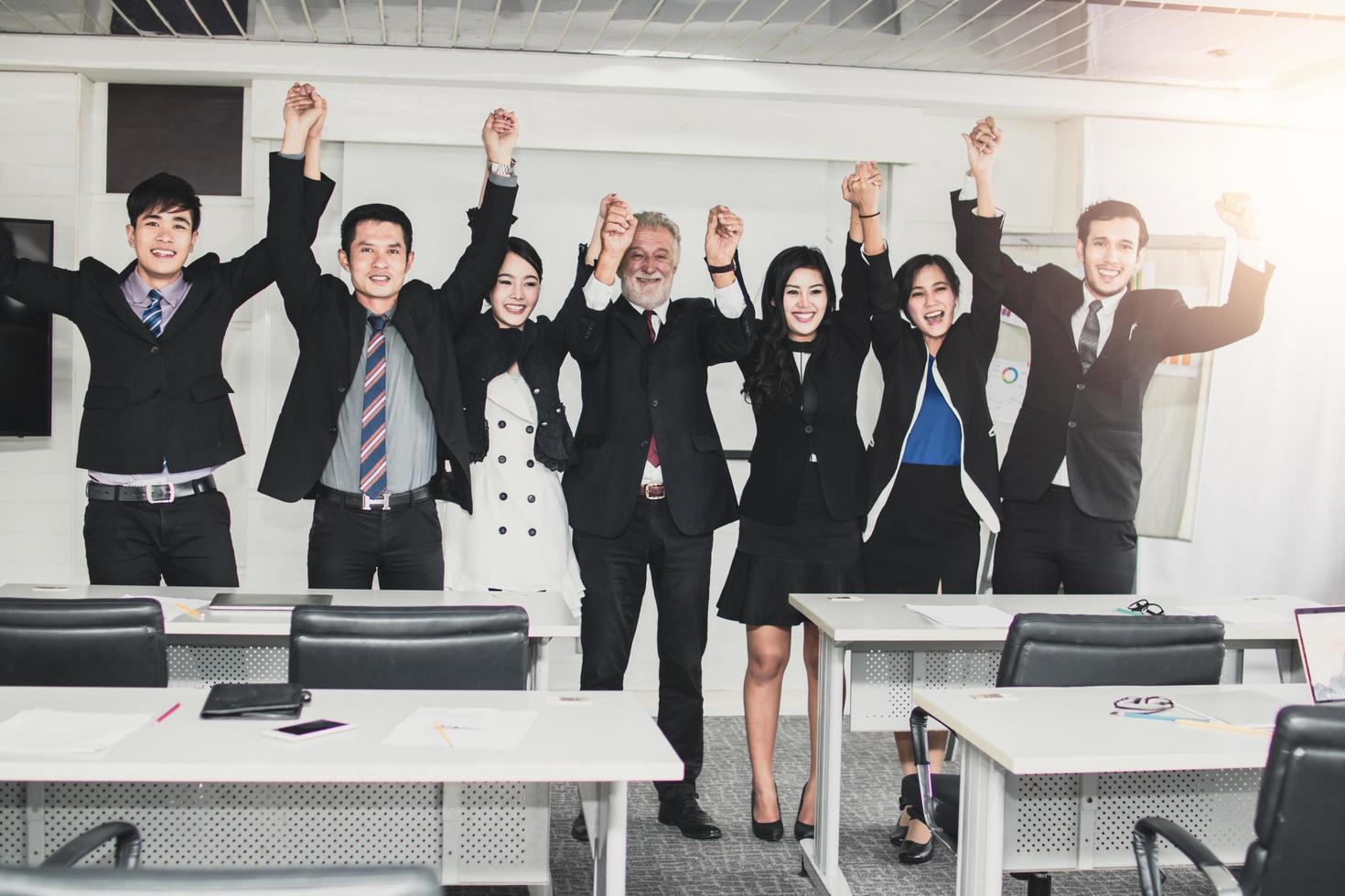 business people show hand up celebrate after finished meeting and seminar in office, success and teamwork concept photo