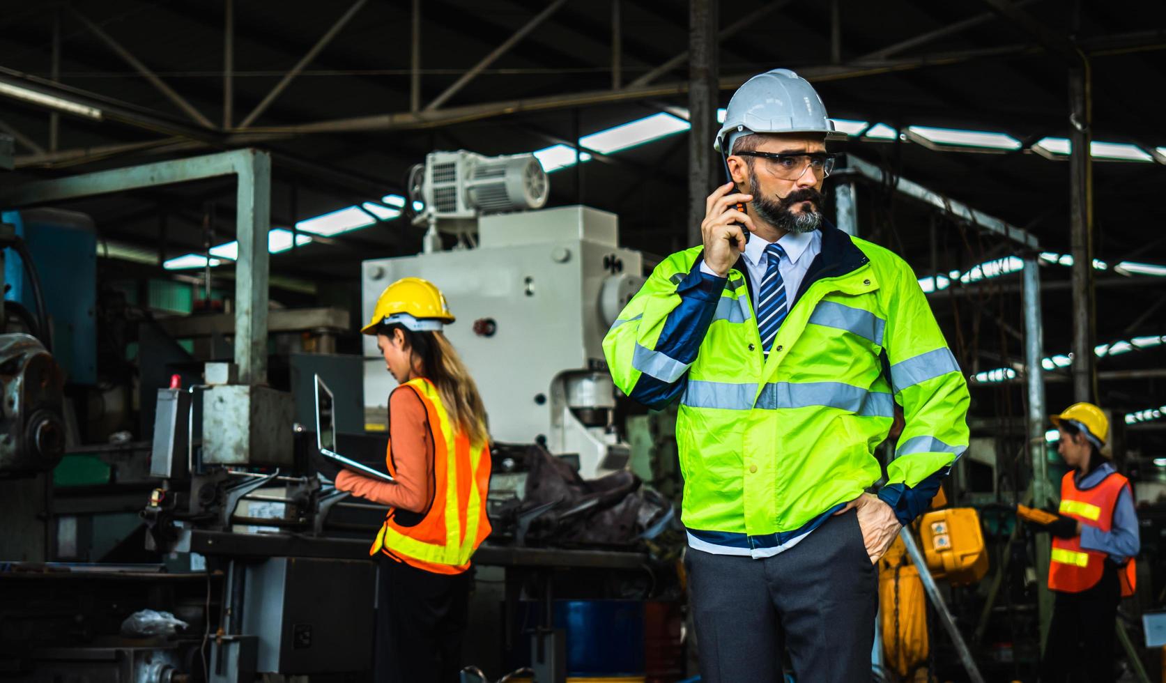 Portrait of successful middle aged Caucasian manager businessman  wearing white helmet holding  radio communication to control worker and check business in industry photo