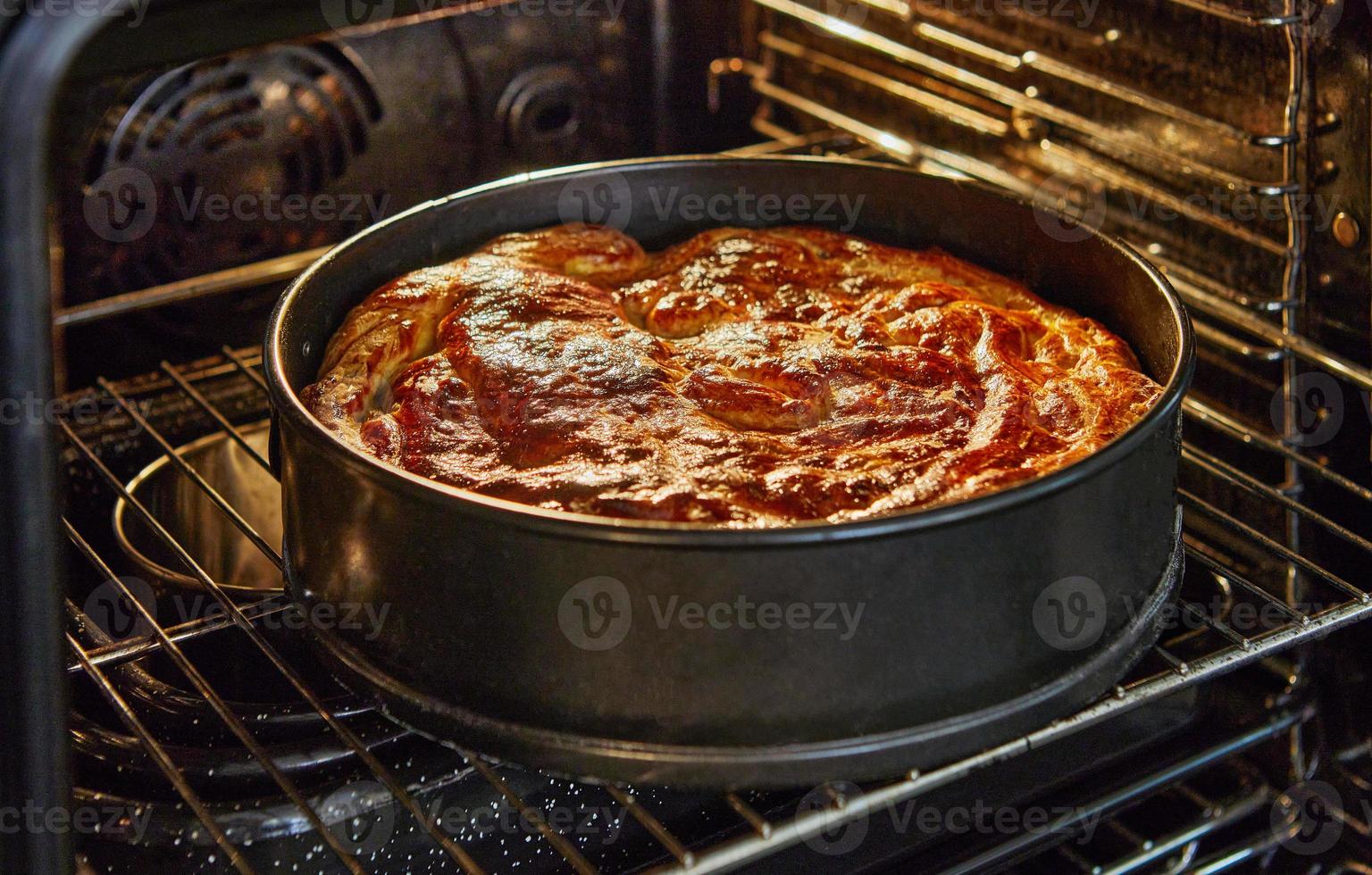 Apple pie in metal mold after baking in the oven photo