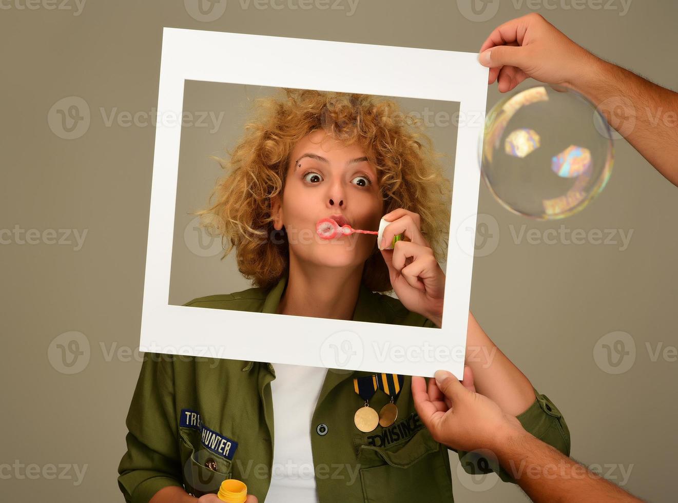 mujer en marco de imagen soplando burbujas foto