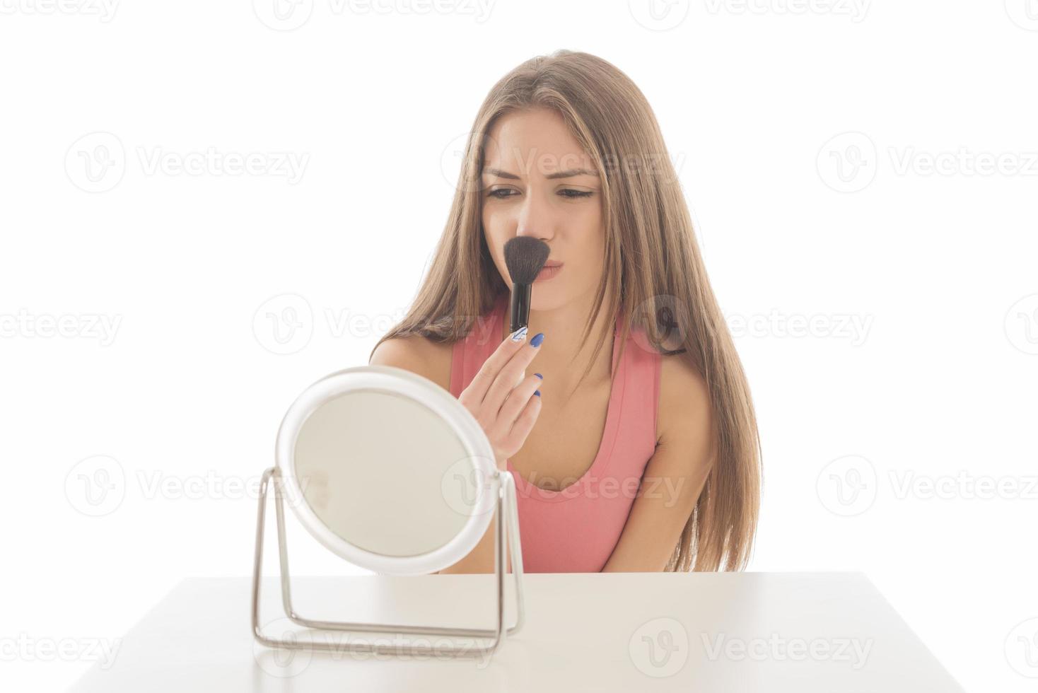 Beautiful woman sitting in front of a mirror. face of a healthy woman applying cream and makeup. Advertisement for skin cream, anti-wrinkle cream, baby face photo