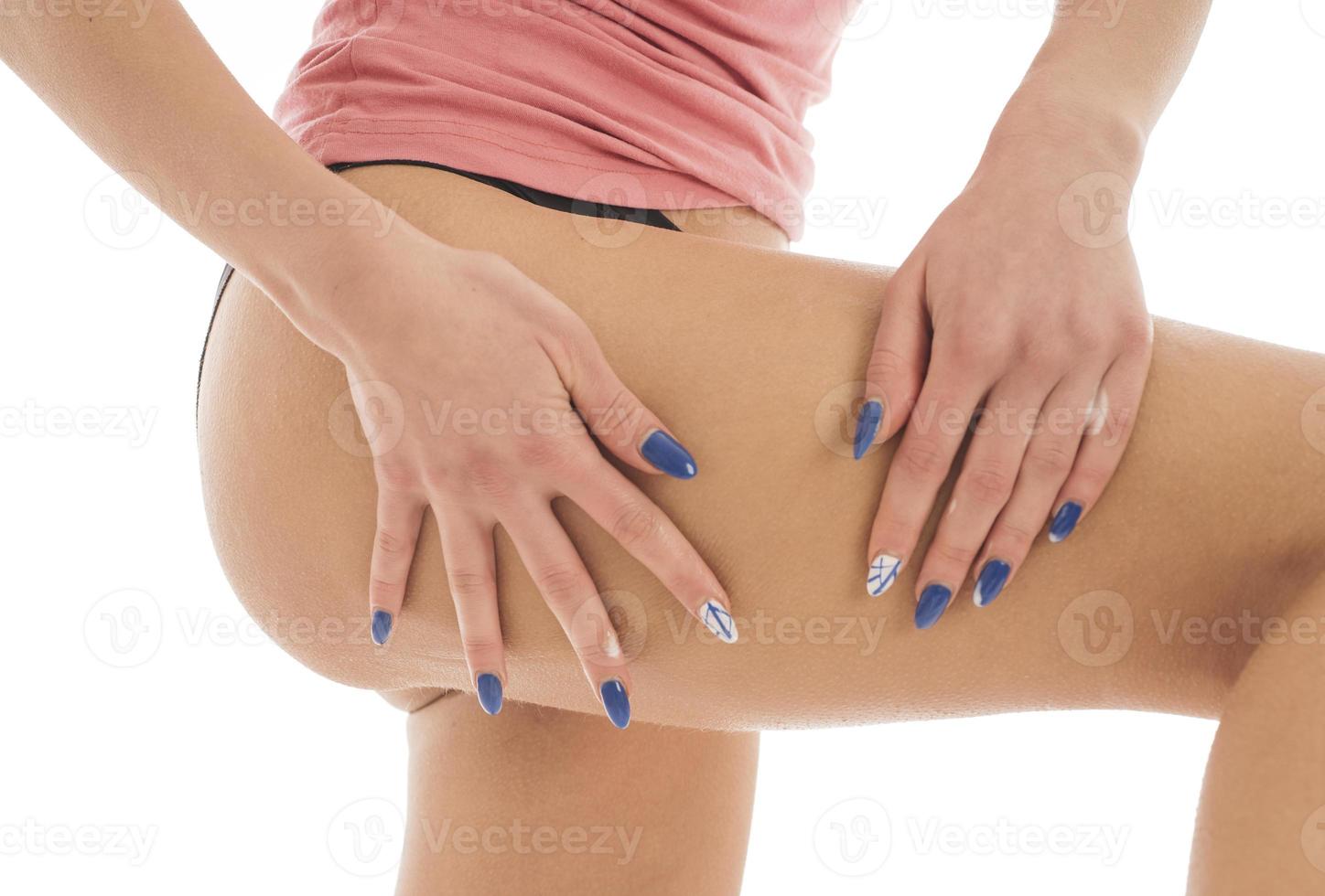 woman applies body lotion on her legs. isolated on white background photo