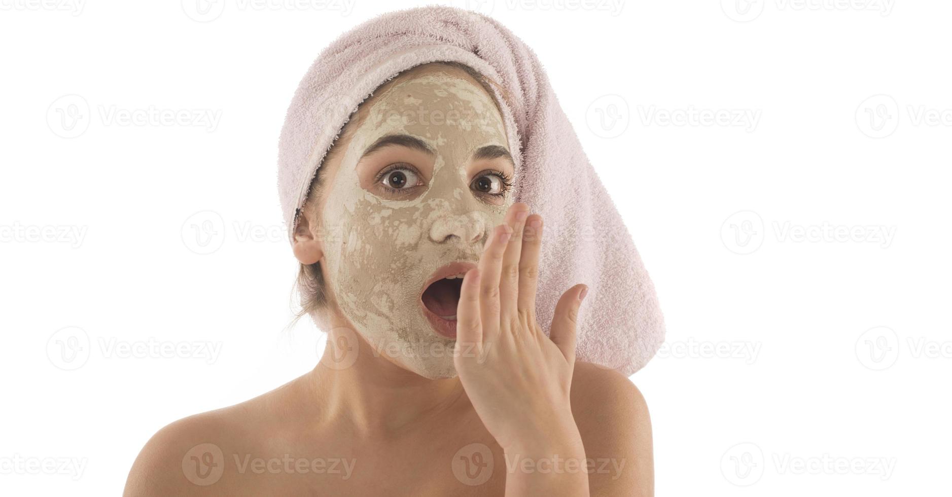 Beauty procedures skin care concept. Young woman applying facial mud clay mask to her face photo