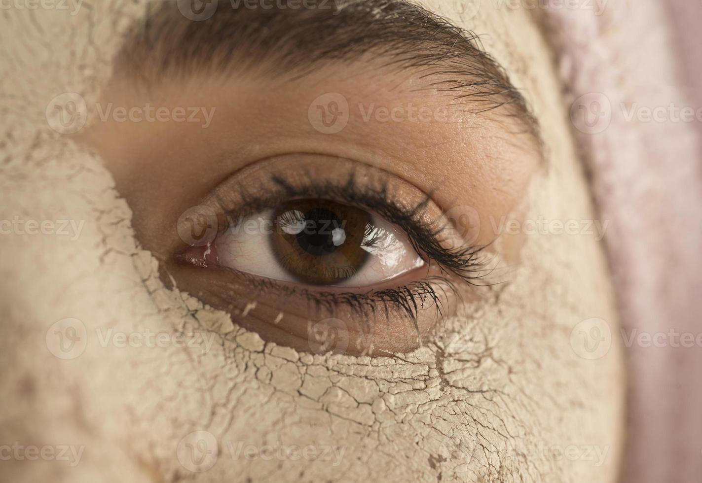 Beauty procedures skin care concept. Young woman applying facial mud clay mask to her face photo