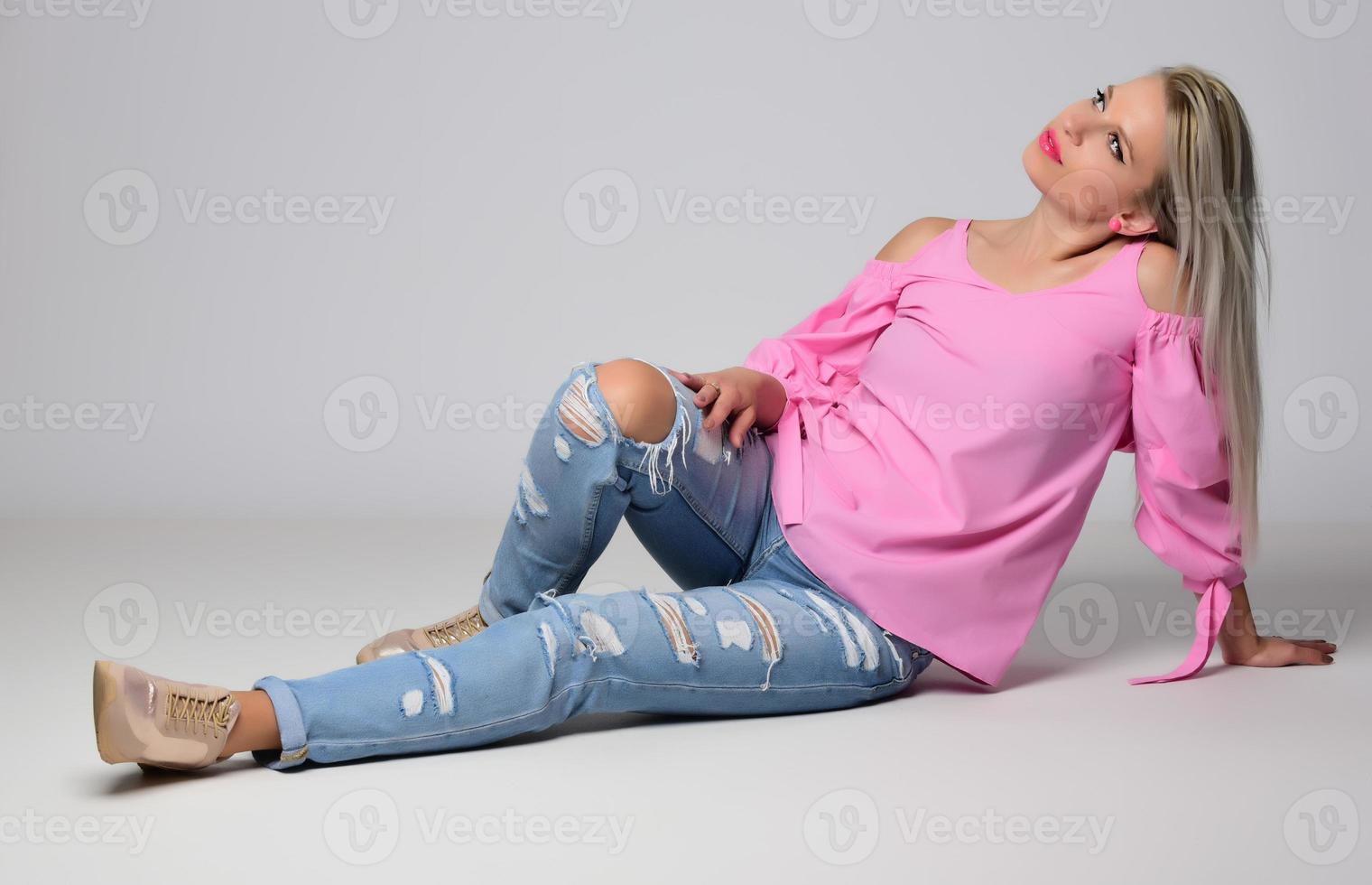 blonde trendy smiling woman wearing modern accessories posing in studio photo