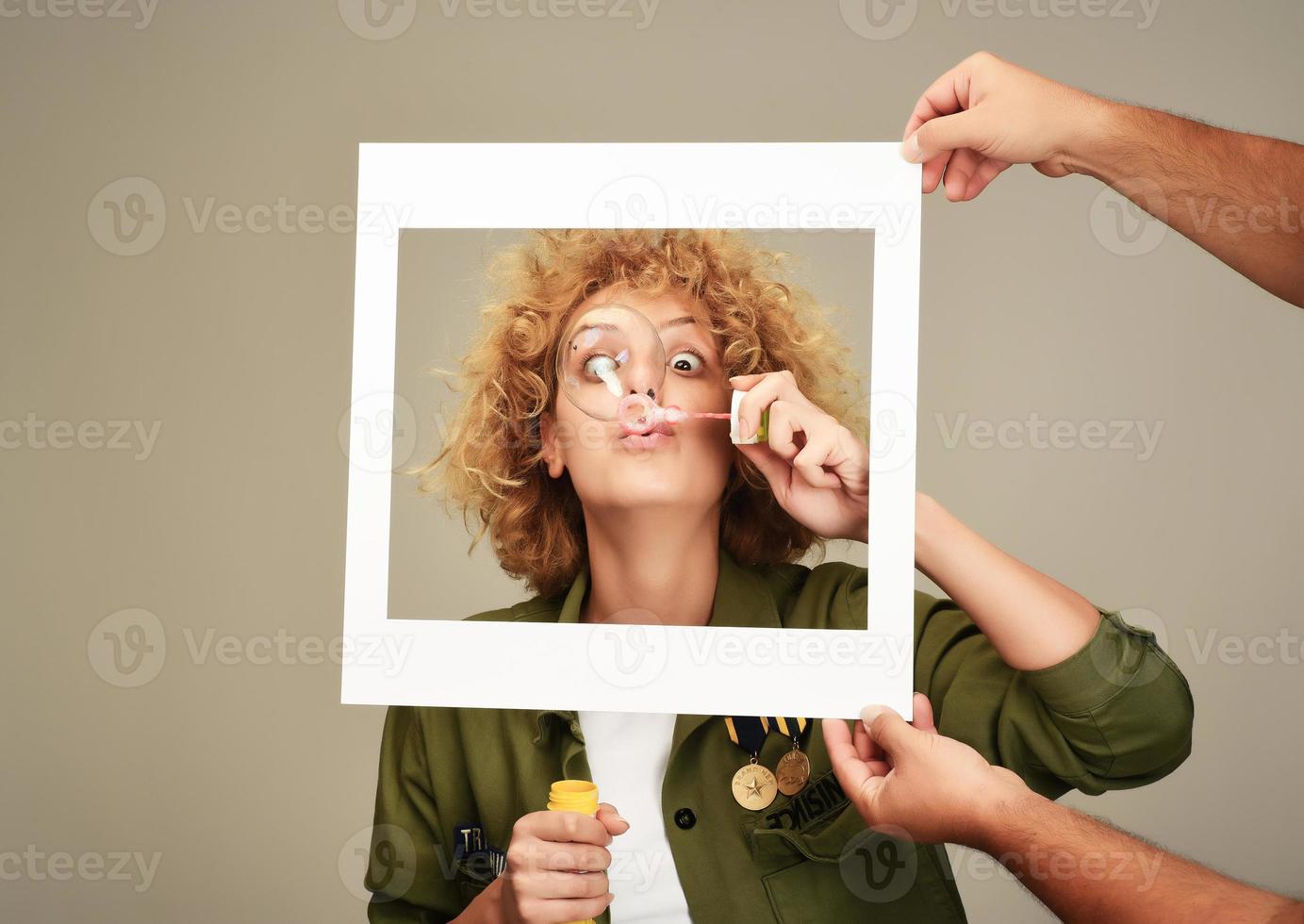 woman in picture frame blowing bubbles photo