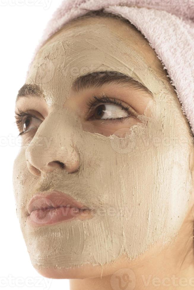 Beauty procedures skin care concept. Young woman applying facial mud clay mask to her face photo