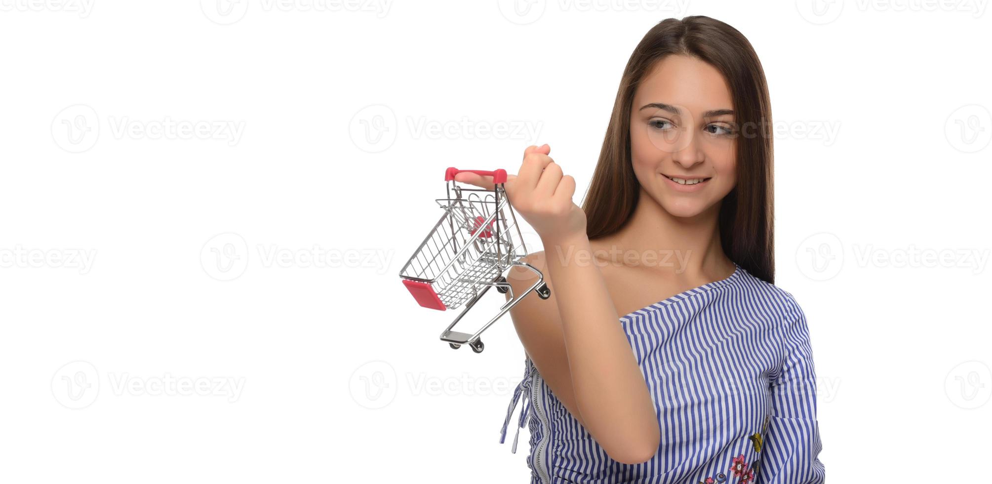 mujer pensó en ir de compras. la chica está pensando en ir de compras. la mujer elige dónde hacer la compra. mujer compradora con mini trolley del supermercado. foto