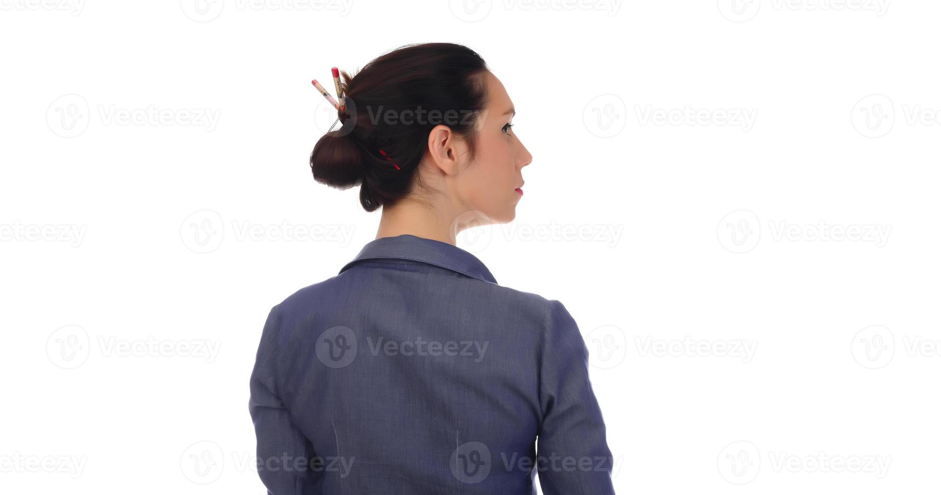 A woman makes a messy hair bun on her head photo