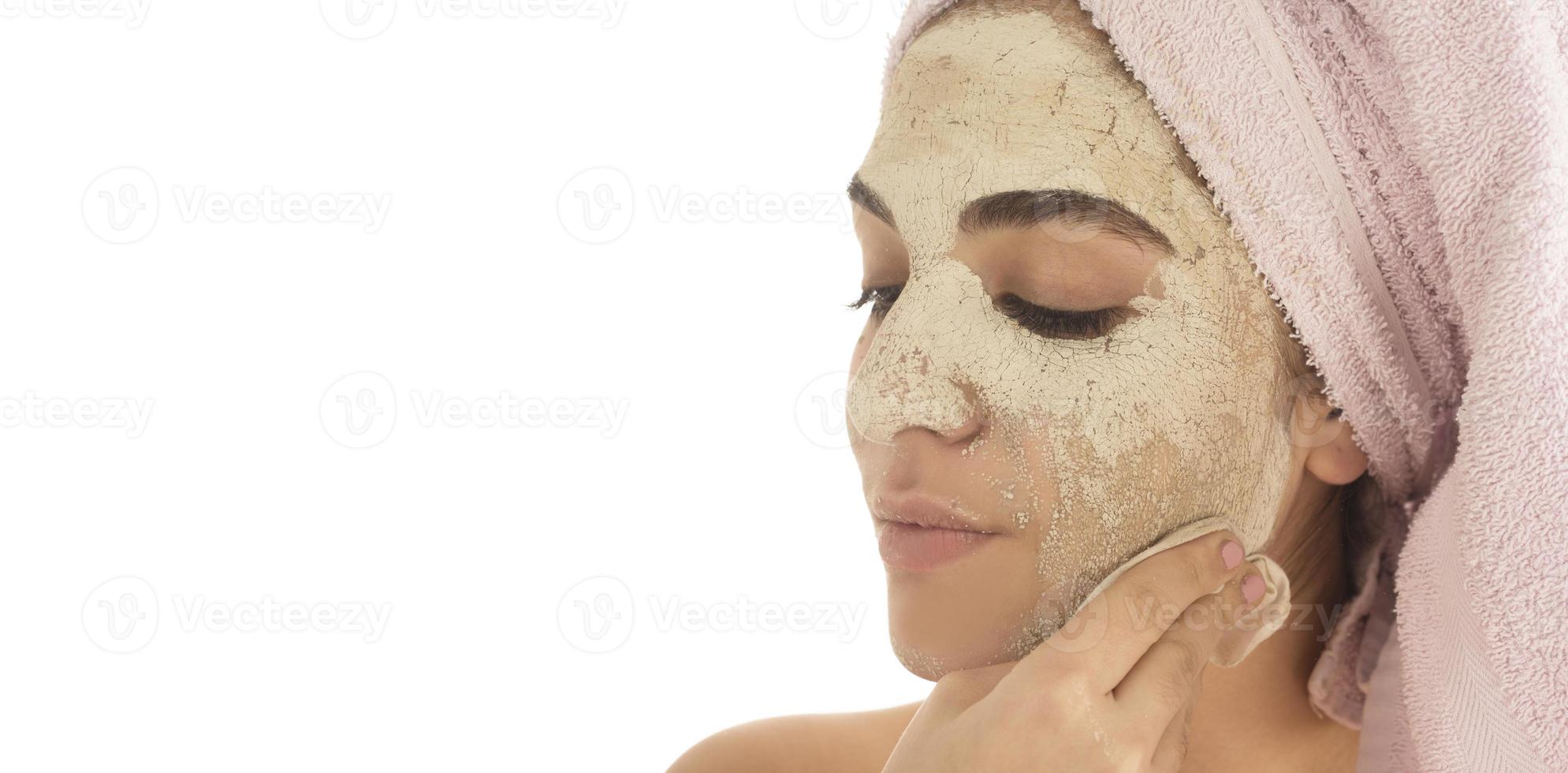 Beauty procedures skin care concept. Young woman applying facial mud clay mask to her face photo