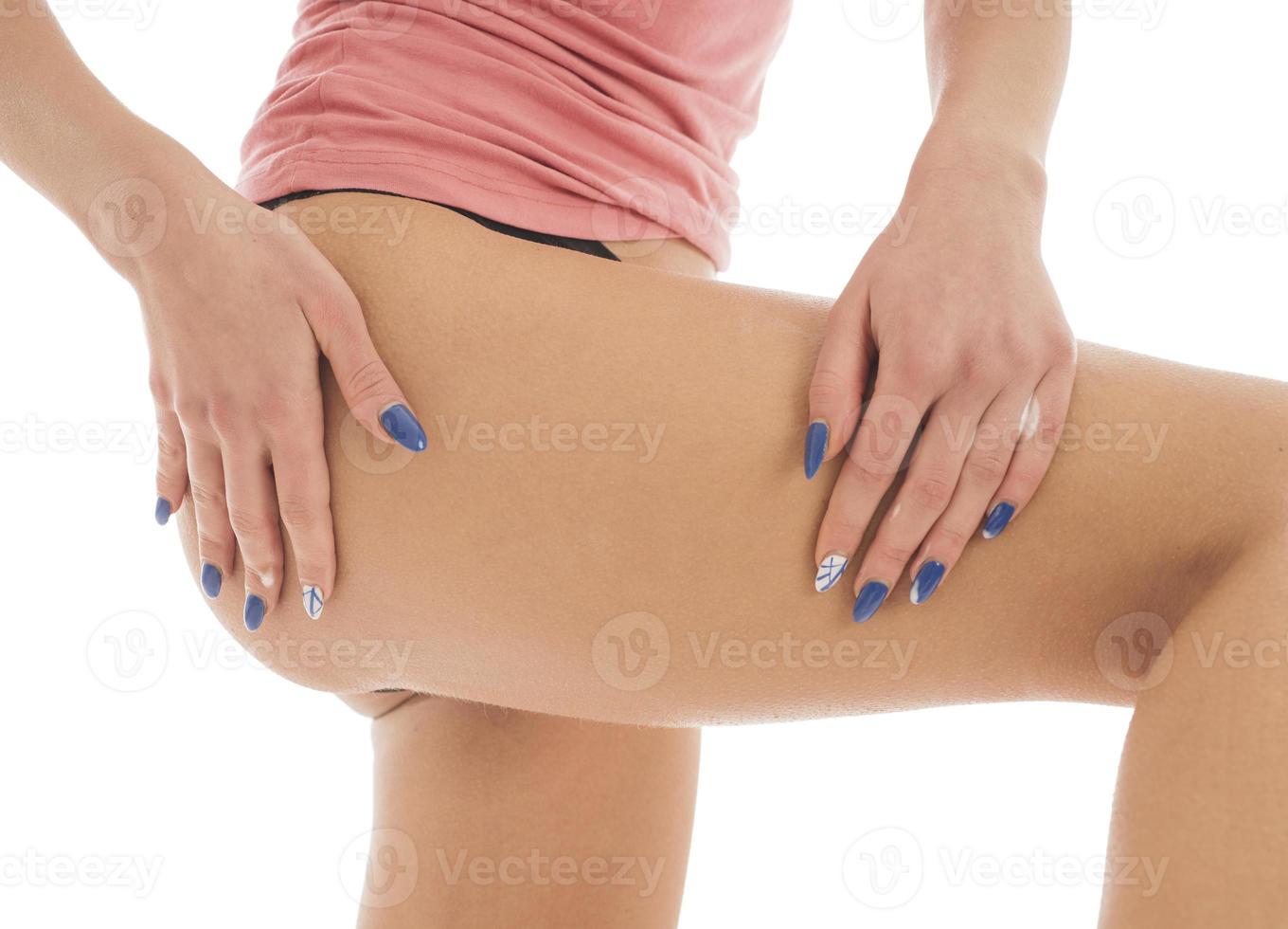 woman applies body lotion on her legs. isolated on white background photo